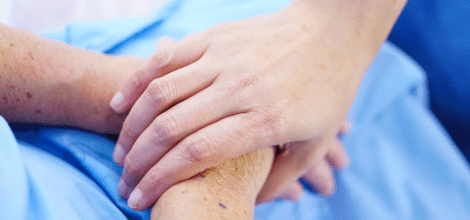 Doctor touching the hand of an elderly female patient
